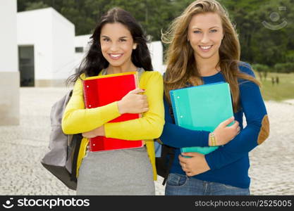 Two beautiful teenage students holding backpacks and smiling