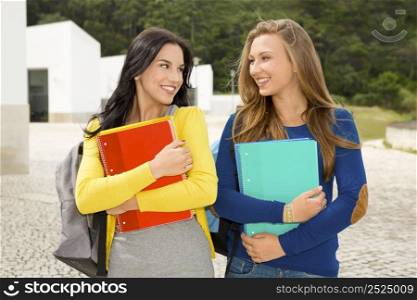 Two beautiful teenage students walking and smiling