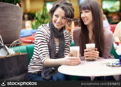 Two beautiful women drinking coffee and chatting
