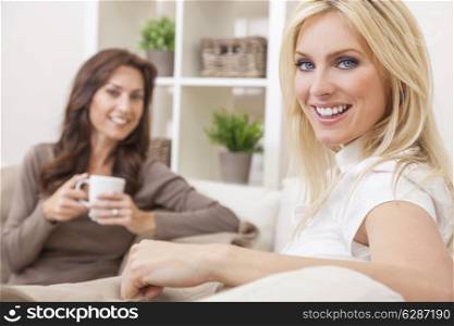 Two beautiful women friends at home drinking tea or coffee together