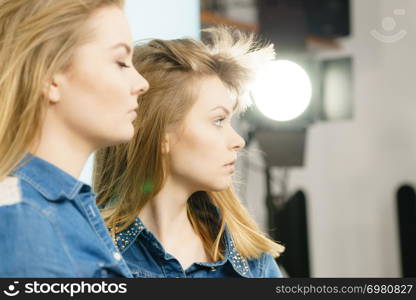 Two beautiful young blonde women having serious face expression. Feminine beauty portrait concept.. Two beautiful young blonde serious women