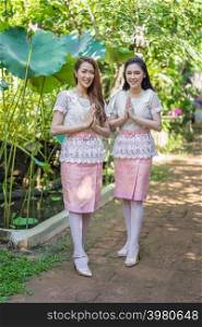 two beautiful young woman in Thai traditional dress is pay respect