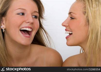 Two beautiful young women with stunning blue eyes and toothy smiles