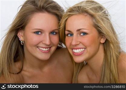 Two beautiful young women with stunning blue eyes and toothy smiles