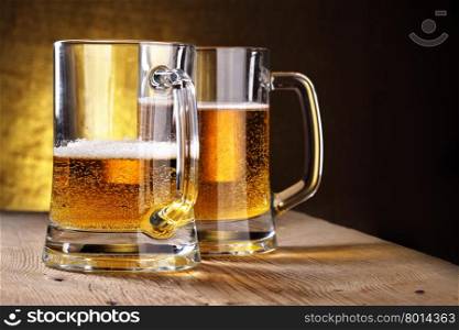 Two beer mugs close-up on wooden table