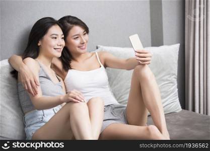 Two best friends taking selfies on a mobile phone