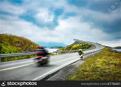 "Two bikers on motorcycles. Atlantic Ocean Road or the Atlantic Road (Atlanterhavsveien) been awarded the title as "Norwegian Construction of the Century"."