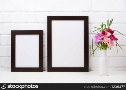 Two black brown frame mockup with pink and red godetia clarkia flowers. Empty frame mock up for presentation design. Template framing for modern art.
