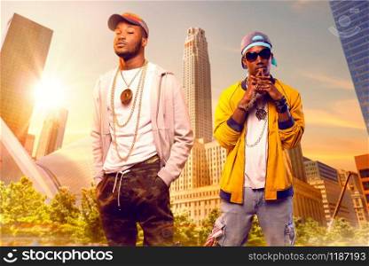 Two black rappers in caps, cityscape on background. Rap performers in city, underground music concert, urban style