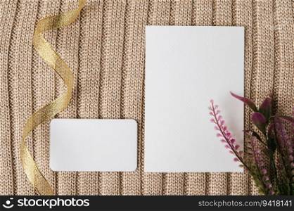 two blank card, gold ribbin and a leaf on a sweater