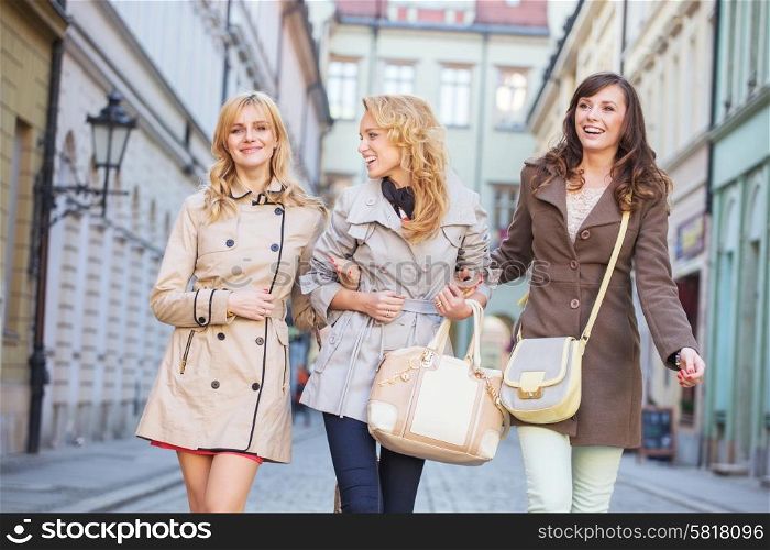 Two blonde and one brunette woman walking
