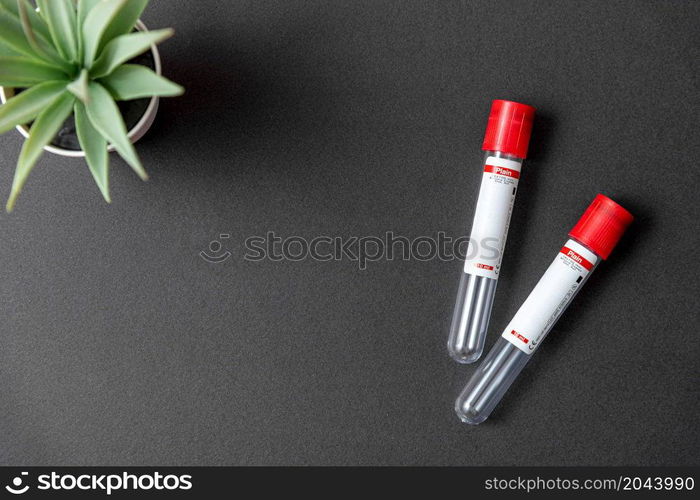 Two blood test tubes on black background with blank text area