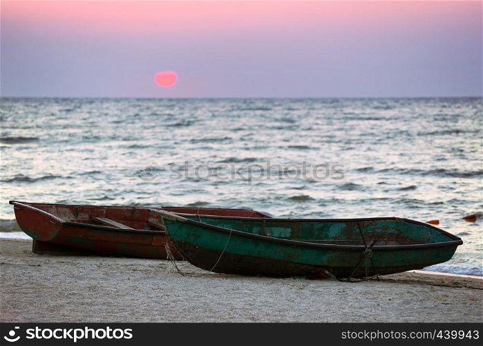 Two boats on the seashore at dawn