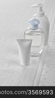 two bottles and tube on white towel