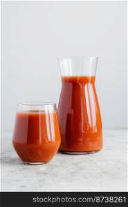 Two bottles of tomato juice containing vitamins isolated over white background. Vertical shot. Freshly squeezed smoothie. Healthy drink