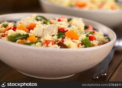 Two bowls of couscous dish with chicken, green bean, carrot and red bell pepper (Selective Focus, Focus on the chicken meat in the middle of the dish)