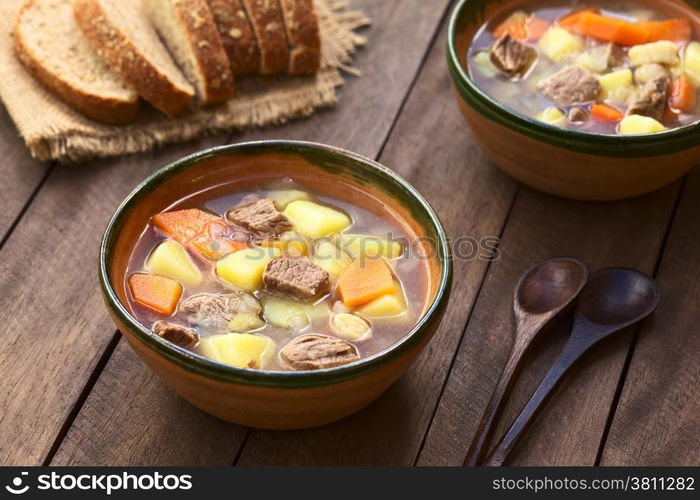 Two bowls of traditional Hungarian soup called Gulyasleves made of beef, potato, carrot, onion, csipetke (homemade pasta) and seasoned with salt and paprika (Selective Focus, Focus in the middle of the soup in the first bowl)