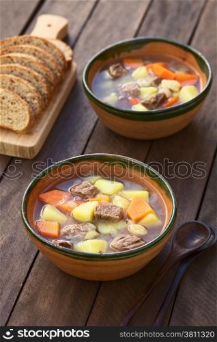 Two bowls of traditional Hungarian soup called Gulyasleves made of beef, potato, carrot, onion, csipetke (homemade pasta) and seasoned with salt and paprika (Selective Focus, Focus in the middle of the soup in the first bowl)