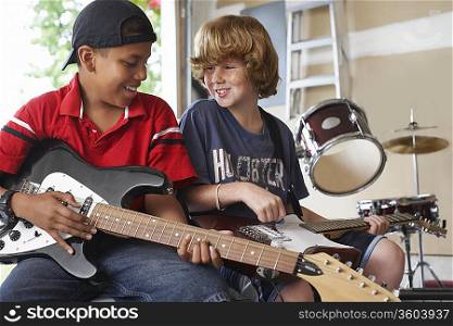 Two boys (10-12) with instruments in garage