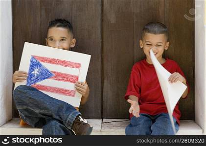 Two boys holding drawing of the Puerto Rican flag