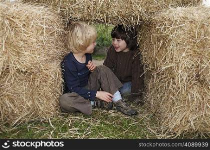 Two boys in hay bales