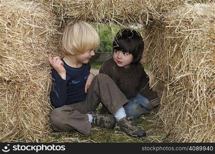 Two boys in hay bales