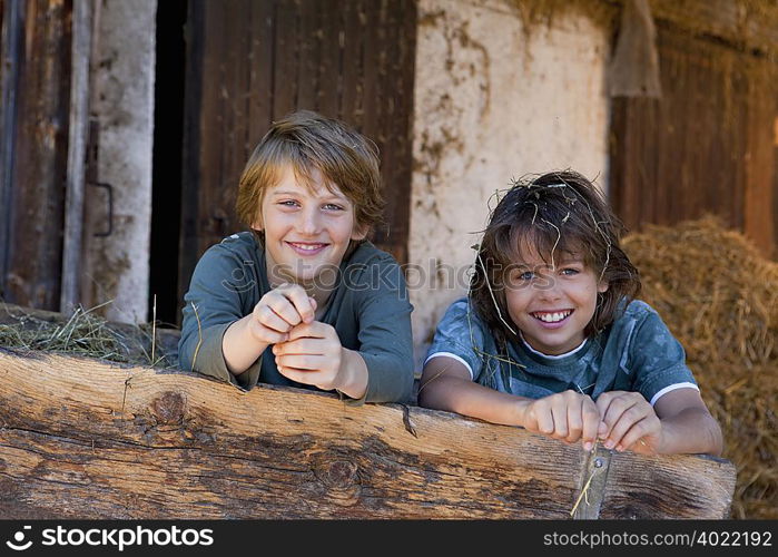 Two boys in haycart, happy