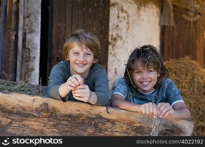 Two boys in haycart, happy