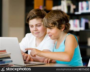 Two boys in library with notebook. Two boys in library