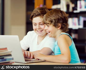 Two boys in library with notebook. Two boys in library