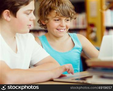 Two boys in library with notebook. Two boys in library