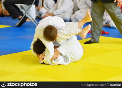 Two Boys judoka in kimono compete on the tatami