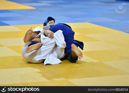 Two boys judoka in kimono compete on the tatami