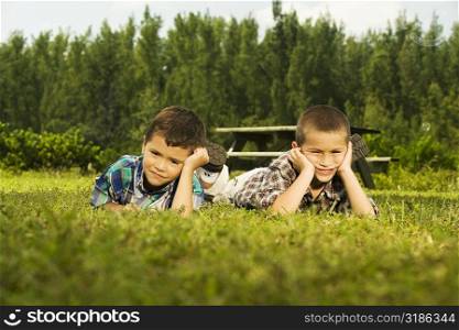 Two boys lying on the lawn