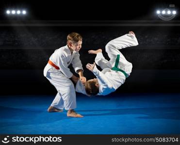 Two boys martial arts fighters at sports hall