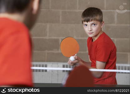 Two Boys Playing Table Tennis Match In School Gym