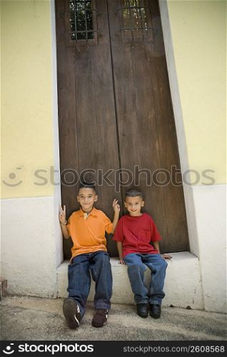 Two boys sitting in doorway