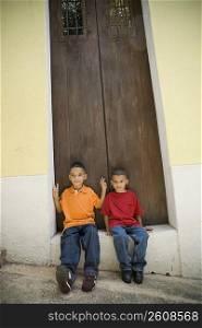 Two boys sitting in doorway