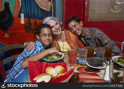 Two boys sitting with their grandmother in a restaurant