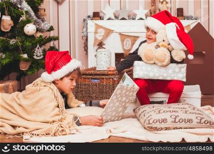 Two boys wearing Santa's hat with christmas decorations background