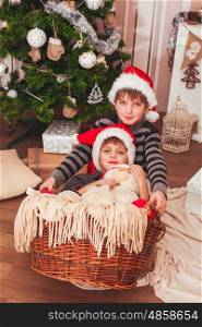 Two boys wearing Santa's hat with christmas decorations background