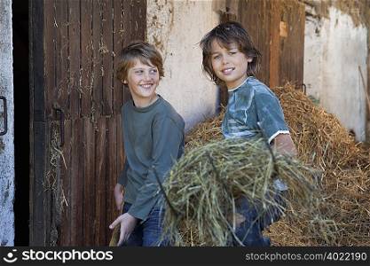 Two boys with hayforks, happy