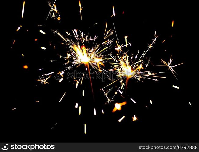Two bright festive New Year Christmas sparklers on black background