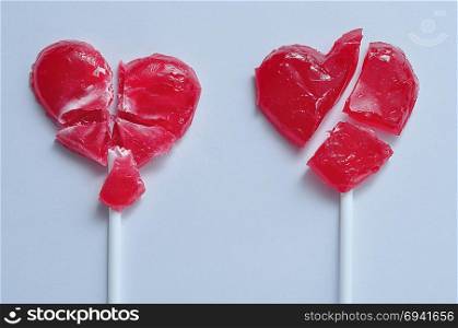 Two broken red heart lollipops symbolizing broken hearts