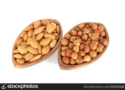 Two brown wooden bowl full of almonds and hazelnuts isolated on white