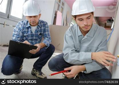 two builders with tablet pc computers indoors