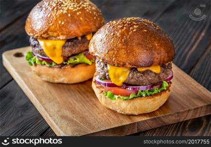 Two burgers on the wooden board close up