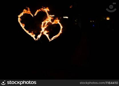 Two burning hearts on a dark background close up. Glowing hearts in the dark. Two burning hearts against a dark background close up