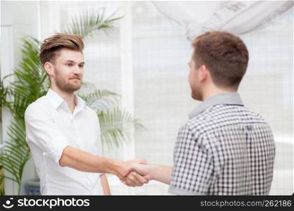 Two business colleagues handshake during meeting.