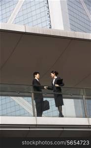 Two Business Colleagues Shaking Hands Outside Office Building